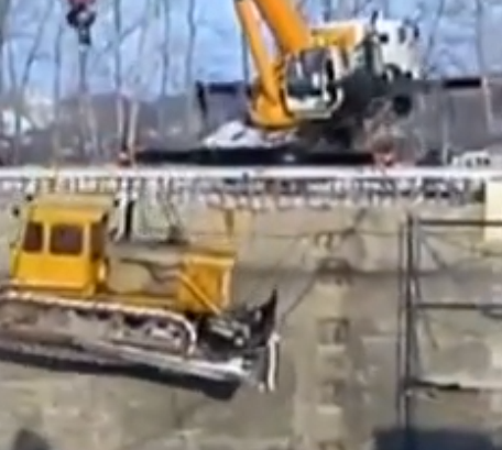 Incredible Video: Watch A Russian Crane Operator Leap To Safety As His Crane And A Bulldozer Topple Into A Cavernous Hole