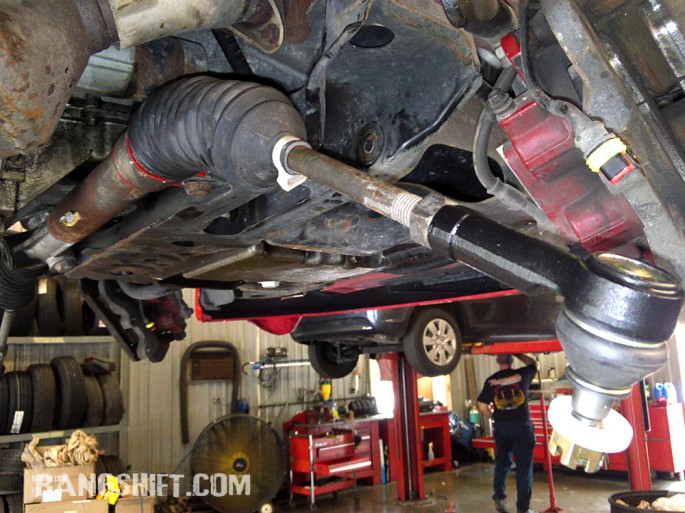 The tired rubber steering rack bushing is replaced with a firmer EP2105 urethane part and new PTE3049 tie rod end installed.