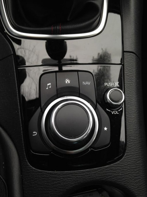 Here's the radio controls for the Mazda 3. This knob and a couple of buttons. We really enjoyed this system and took to it quickly. Clearly Mazda is not getting down into the same insane redundancy that companies like Ford and GM are with knobs and touch screens, etc. While older people may struggle to get a handle on this as quickly as the younger set, it really cleans up the interior and is super easy to use when driving. This also controls navigation and other functionality. 