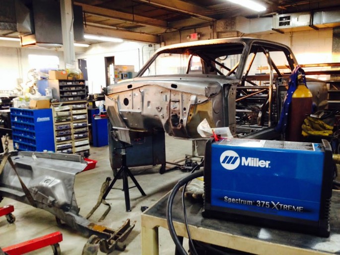 With 10 minutes off the clock and a stead hand, Kevin removed front of the car. He's going to be custom building a new front subframe and suspension system and that's going to have nothing to do with the factory stuff so, bombs away! The Miller plasma cutter made short work of that job. 