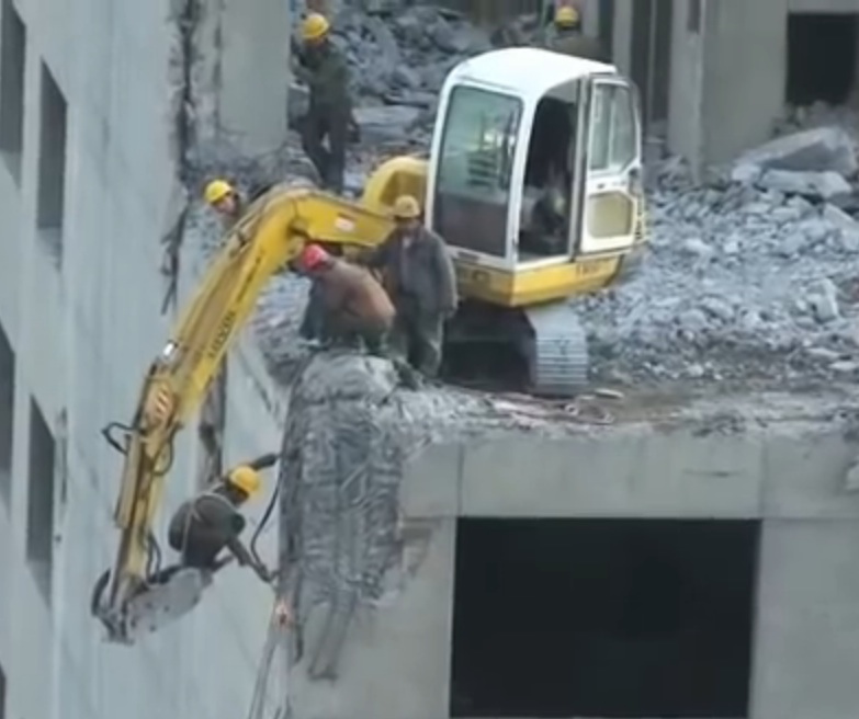 Incredible Video: Watch A Chinese Construction Worker Get Dangled Over the Edge Of A Building With A Torch During Its Demolition!