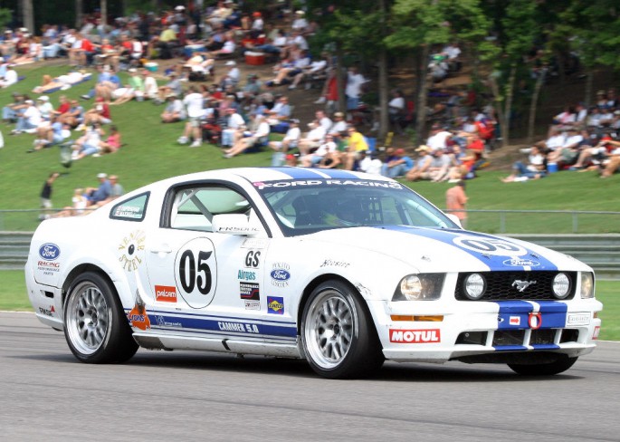 Racing past the crowd, Empringham aboard the wheel of the #05 Mustang