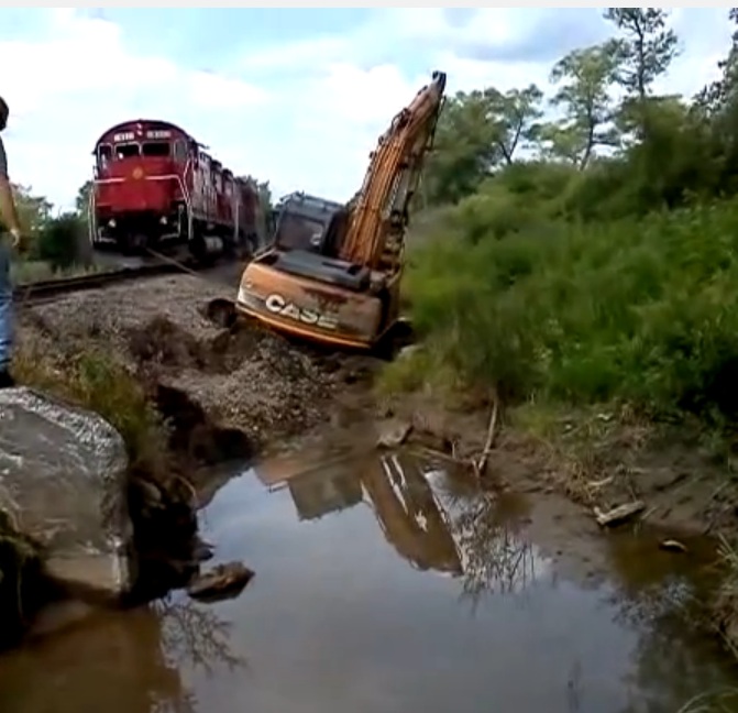 Watching A Locomotive Pull A Stuck Excavator Out Of The Muck Is Strangely Awesome