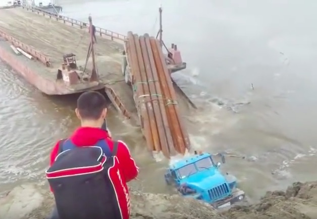 Slow Motion Calamity: Backing This Pipe Lugging Big Rig Onto An Unsecured Barge Was A Bad idea