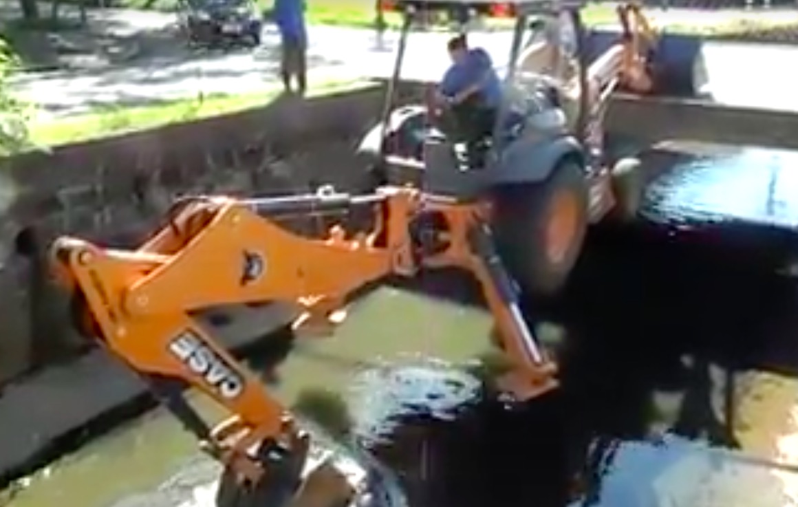 Watch This Backhoe Operator Deftly Lower Himself Into A Storm Runoff Channel