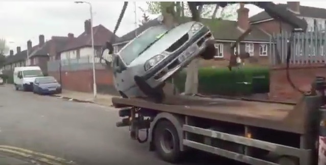 Watch A Crazy Irishmen Try To Keep His Car From Being Towed By Driving It Off The Truck!